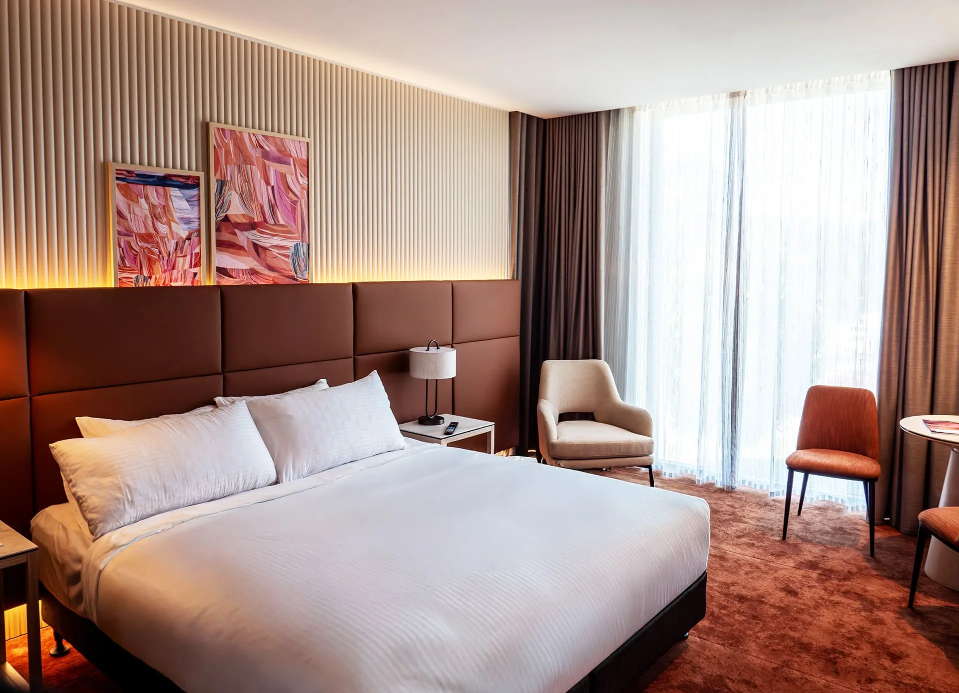 Hotel bedroom with a timber slat feature wall behind the bed
