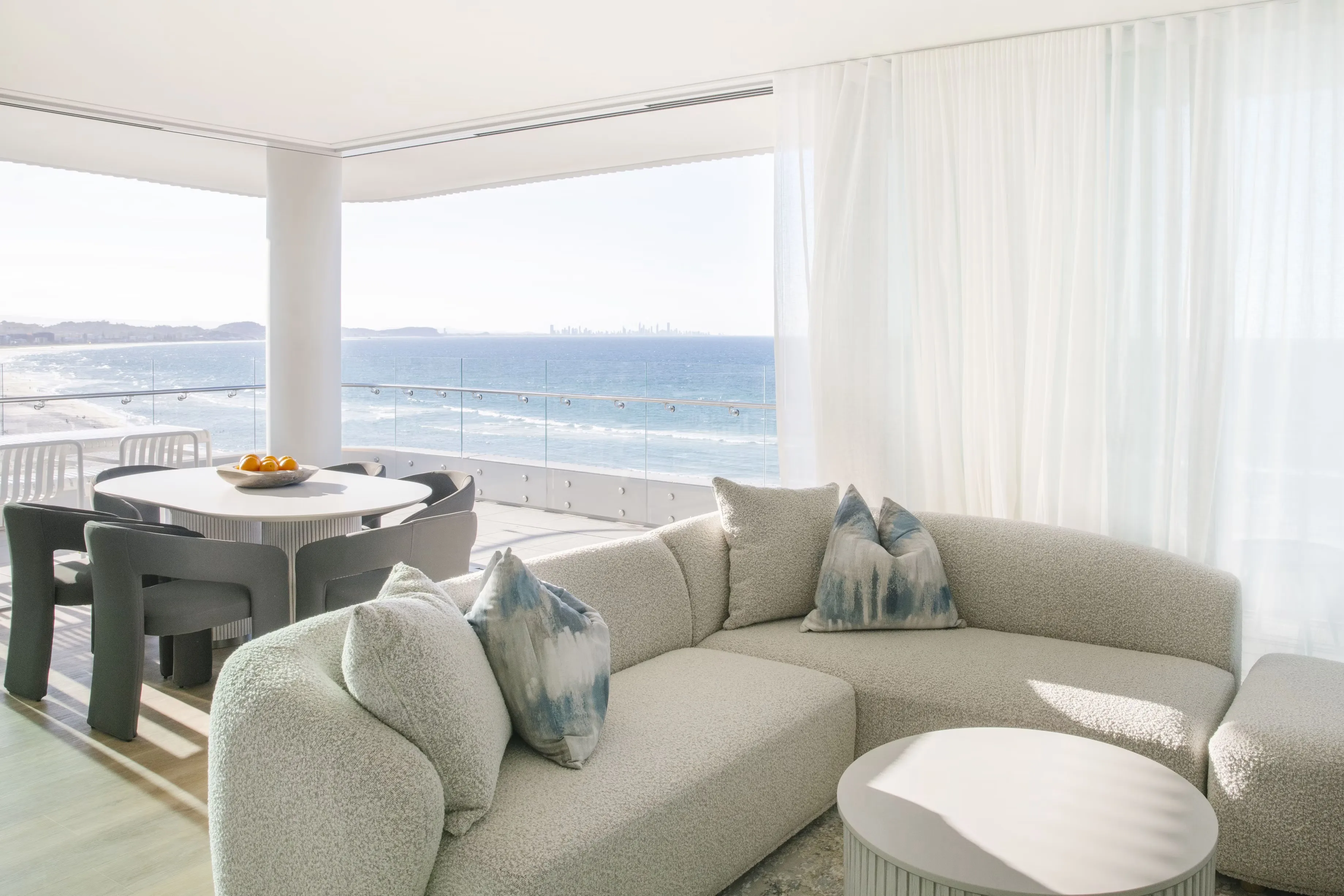Apartment living and dining area opening onto an ocean-front balcony